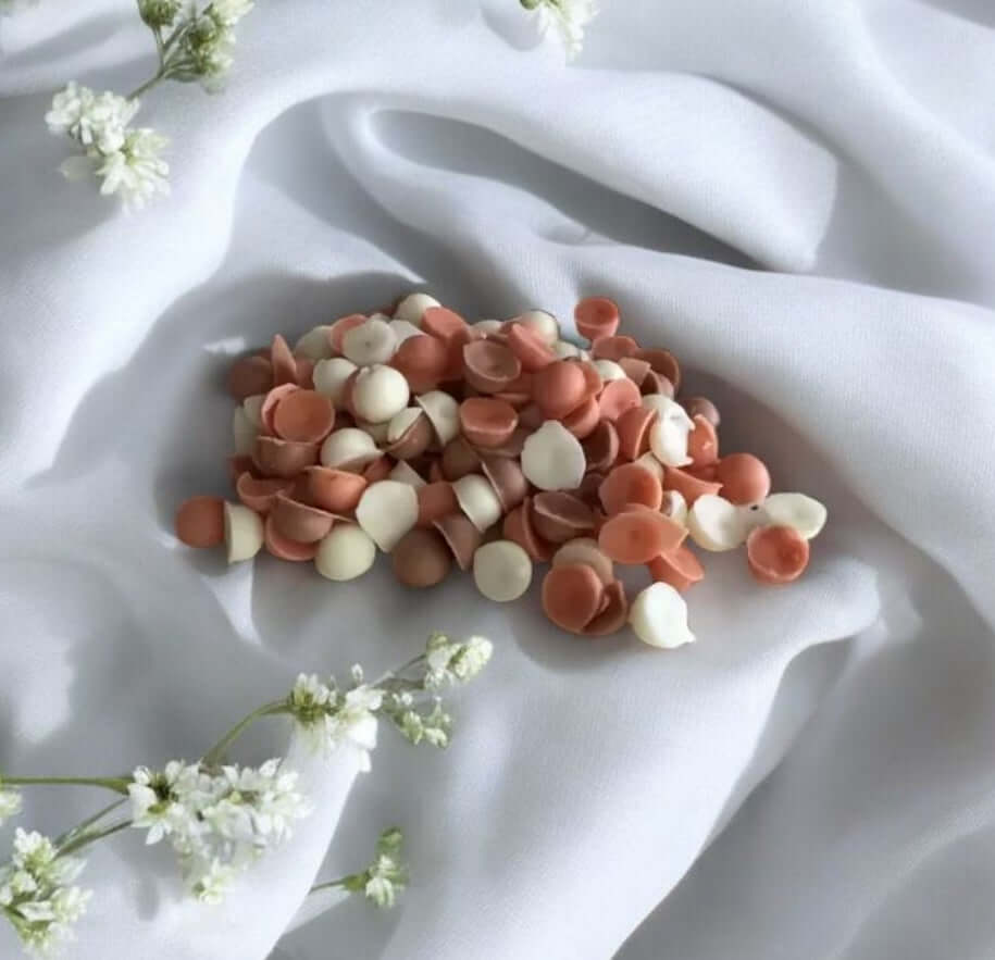 parfum tarte à citrouille épicée - Mélange de perles parfumées sur tissu blanc avec fleurs.